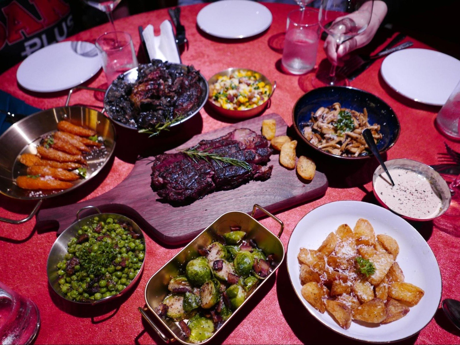 Overhead view of shared steak cuts and seasonal sides served family-style at El Toro restaurant in Thao Dien.