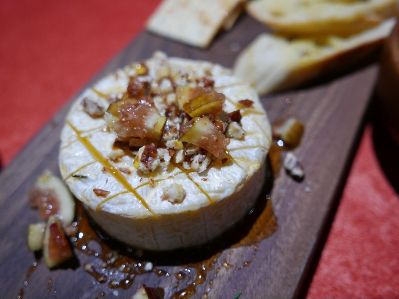 Close-up of roasted brie melting beneath fresh figs and fig jam, served warm at El Toro restaurant in Thao Dien.