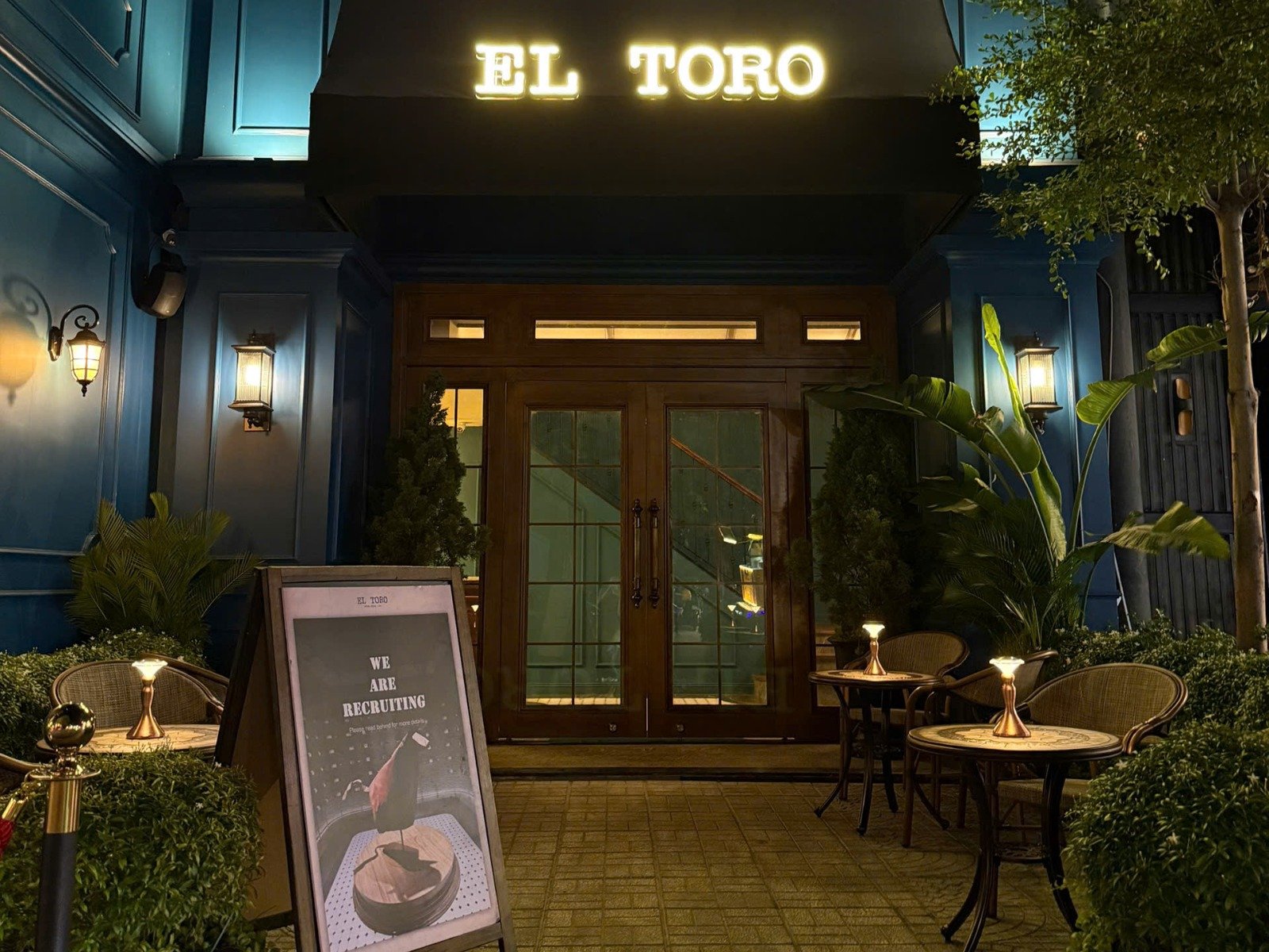 Outside view of El Toro restaurant in Thao Dien at night with warm lighting and green exterior